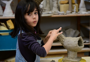 Kind arbeitet an einer Keramik