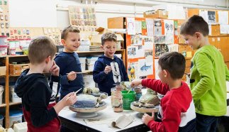 Kindern formen Figuren aus Ton